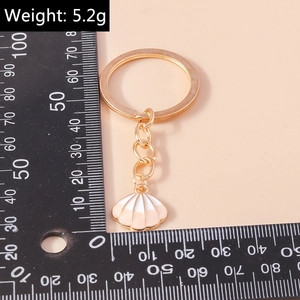 Detailansicht eines rosa-weißen Muschel-Schlüsselanhängers aus Goldlegierung, 5,2g