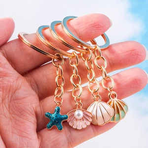 Detailaufnahme von Meeres-Anhängern mit Seestern und Muscheln vor einem hellblauen Himmel