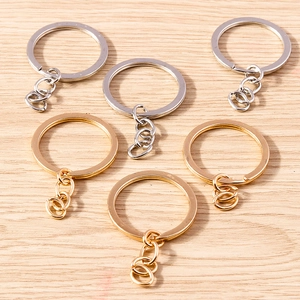 Close-up of polished gold and silver alloy split rings with short chains on wood background