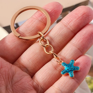Süßer Seestern Schlüsselanhänger in Türkis mit goldenem Ring und Handgrößen-Demonstration