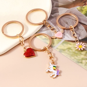 Detail of cute cartoon keychains featuring unicorn, glitter hearts, and pink daisy designs
