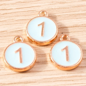 Detailed view of three light blue enamel number one charms with gold metal borders