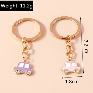 Détail de porte-clés voiture mignons en violet et rose avec des strass et anneau doré