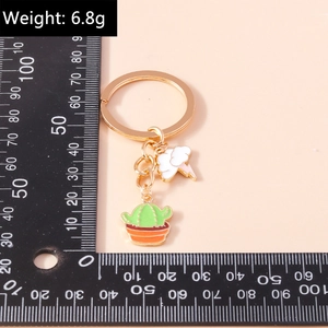 Macro shot of colorful enamel cactus and cloud charms with measurement ruler
