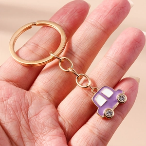 Vue détaillée du porte-clés voiture violet avec roues en strass et anneau en métal doré