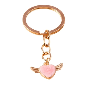 Cartoon pink heart pendant keychain with metal wings and gold chain on white background