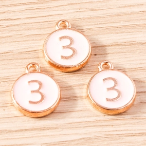 Detailed macro of rose gold and white enamel number 3 charms for DIY jewelry making