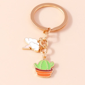 Detail of metal keychain featuring green cactus and white cloud with pink lightning bolt