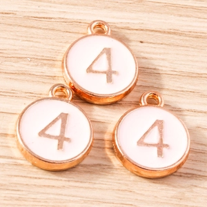 Macro shot of three rose gold number 4 charms with white enamel for DIY jewelry making