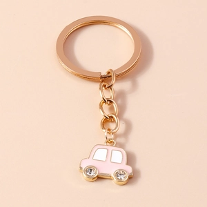 Détail du porte-clés voiture rose avec roues en cristal et anneau doré poli