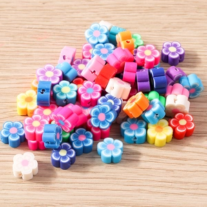 Gros plan de perles fleurs en pâte polymère colorée pour création de bijoux DIY