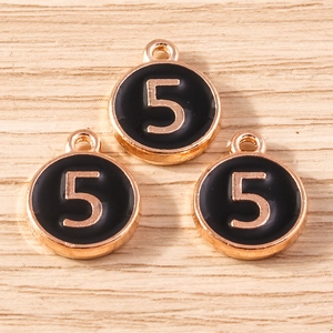Macro shot of three round number 5 charms with black enamel and gold metal plating