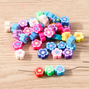 Gros plan de perles de fleurs en pâte polymère colorées avec trous pour bijoux DIY