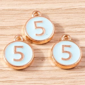 Detailed macro of rose gold round charms with light blue enamel and number five inlay