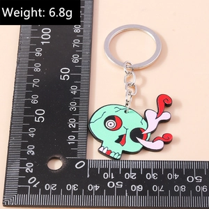 Vue détaillée d'un porte-clés tête de mort zombie vert sur fond de couleur pêche