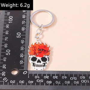 Vue détaillée d'un porte-clés tête de mort en flammes avec lunettes de diable rouge et métal
