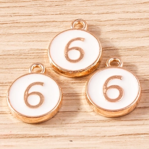 Detailed macro view of three white alloy pendants with golden number 6 for DIY jewelry