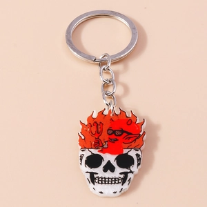 Porte-clés tête de mort en feu avec petit diable rouge et flammes sur fond beige