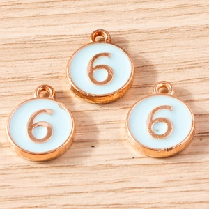 Detailed macro view of three rose gold alloy number 6 charms with light blue enamel inlay