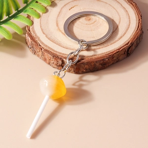 Chic lollipop keychain featuring yellow gradient resin candy on rustic wood slice