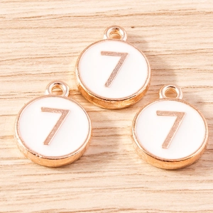 Macro shot of three round number 7 charms with rose gold edges for DIY jewelry