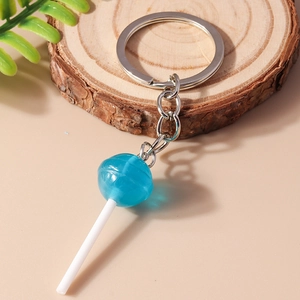 Creative blue lollipop keychain made of resin on a natural wood slice background