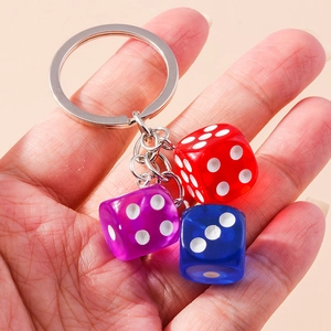Close-up of colorful resin dice keychain held in hand showing high transparency details