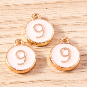 Close-up of pink round enamel number 9 alloy charms with gold plating for DIY jewelry