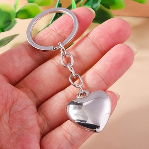 Portachiavi a cuore in lega d'argento lucido con finitura a specchio tenuto in mano