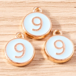 Detail of round number 9 alloy pendants with light blue enamel and rose gold plating