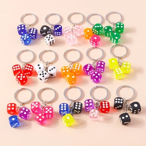 Flat lay of colorful acrylic resin dice keychains in various vibrant color combinations
