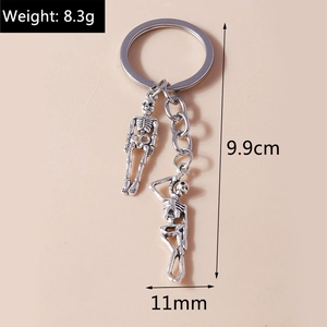Retro silver metal keychain with skull pendants showing 9.9cm length measurements