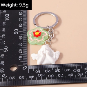 Detail view of cute resin angel pendant with acrylic green flower and metal key ring