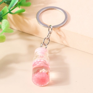 Detailansicht eines rosa Treibflaschen-Schlüsselanhängers mit Muscheln und Glitzer