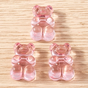 Close-up of three pink translucent resin bear charms for DIY jewelry and accessories
