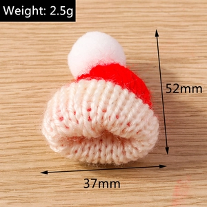 Detail view of mini red and white knitted Christmas hat with 52mm height and 37mm width dimensions