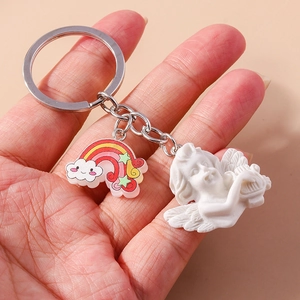 Cute angel and rainbow cloud keychain accessory held by hand with minimalist silver ring