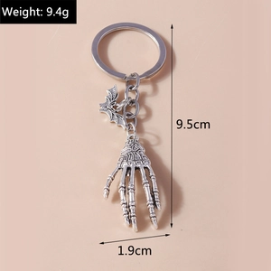 Detailed view of vintage silver skeleton hand keychain with bat pendant and dimensions