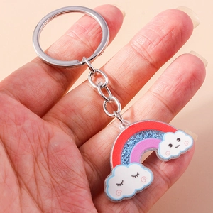 Dettaglio di un simpatico portachiavi arcobaleno con nuvole sorridenti e glitter blu