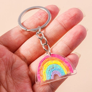 Vista a mano di un portachiavi arcobaleno in acrilico colorato con anello in metallo