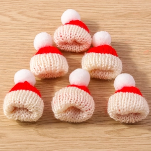 Miniature knitted Christmas hats in red and cream white with pom-poms for DIY crafts