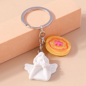 Detailed shot of resin cherub angel keychain with a cute yellow bear charm on a ring