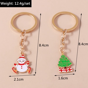 Close-up of snowman and Christmas tree keychains with colorful enamel and gold plating