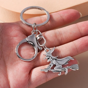Detail of antique silver witch on broom keychain with lobster clasp and metal chain link