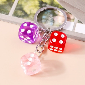 Close-up of three translucent acrylic resin dice on a silver metal keychain