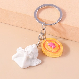 Macro detail of cute white resin angel playing flute and orange star keychain pendant