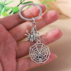 Detail of silver spider and web pendant with skull charm on gothic style keychain
