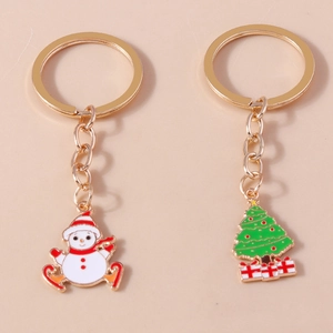 Detailed close-up of colorful snowman and Christmas tree keychains with gold finish charms