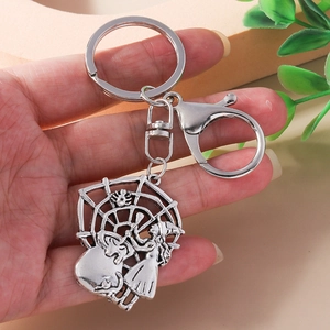 Detail of vintage silver Halloween keychain with witch and spider web metal charms
