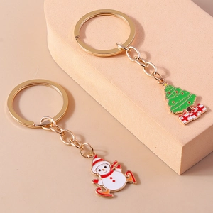 Detail of Christmas snowman and tree keychains with gold metal rings and glossy enamel